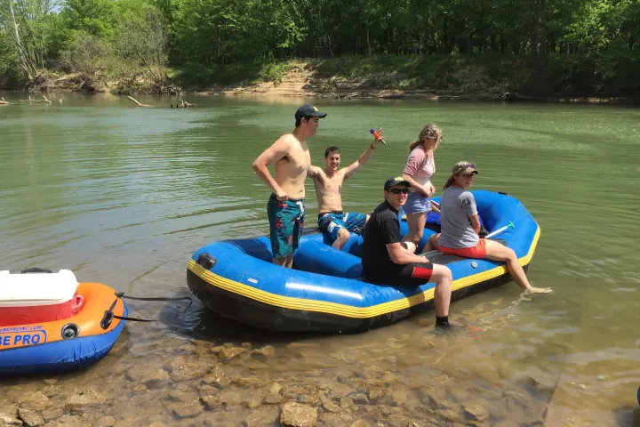 A family climbing into an inflatable raft