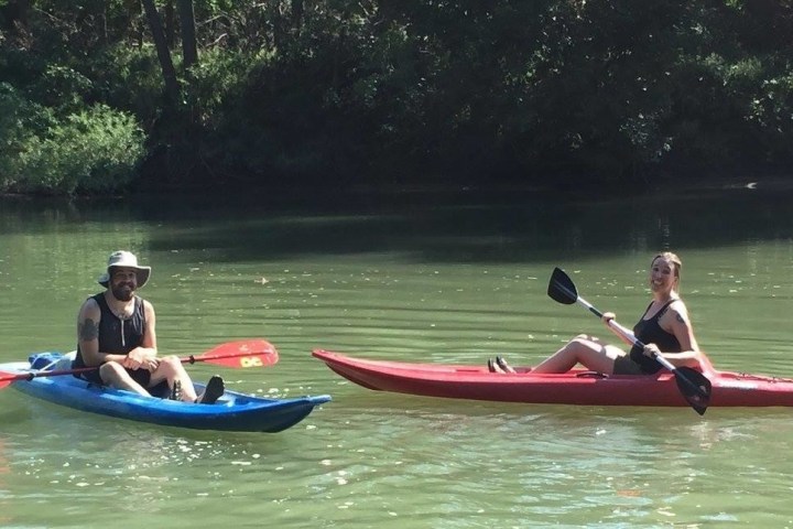 A couple enjoying a single kayak trip on the river