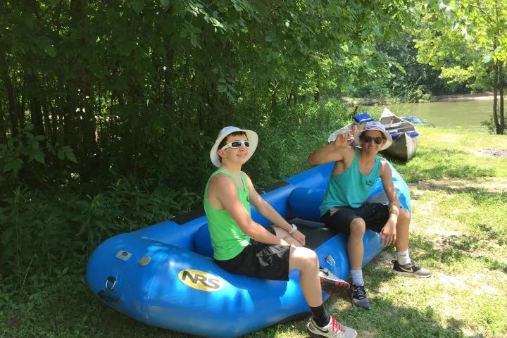 Two brothers sitting on an inflatable raft